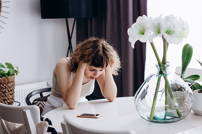 Young woman frustrated and upset at home, highlighting family conflict and struggles with irresponsible sister and future hopes.