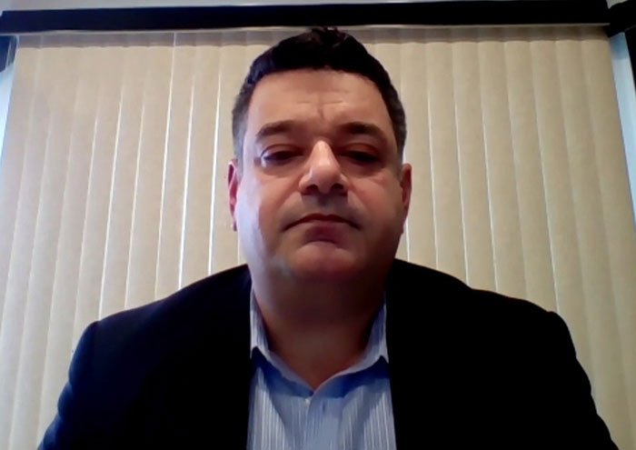 Campbell's executive in a virtual meeting, serious expression, discussing leaked audio and soup ingredients controversy.