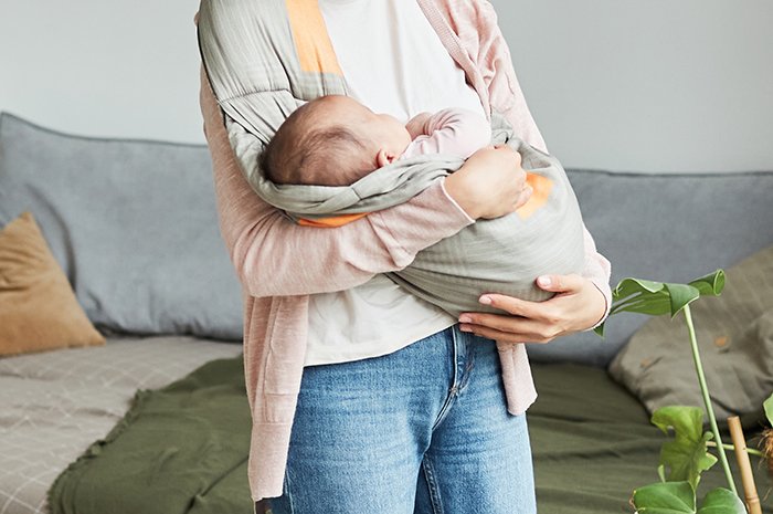 Young mother holding baby, symbolizing family conflict and a robbed future for the younger kid.