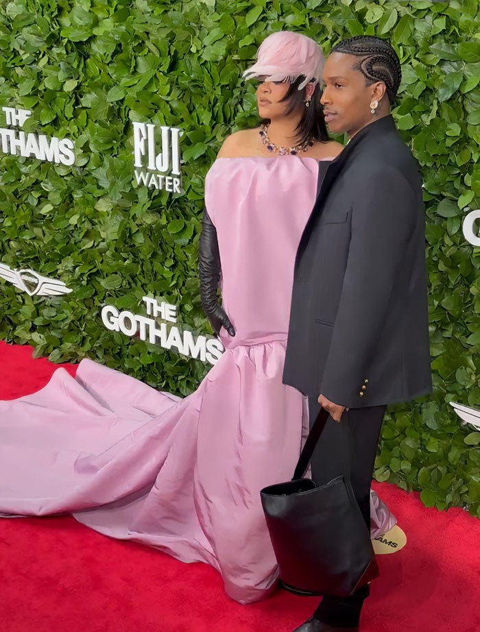 Rihanna on the red carpet in a pink gown with a large black bag, sparking wild reactions about the diaper bag.