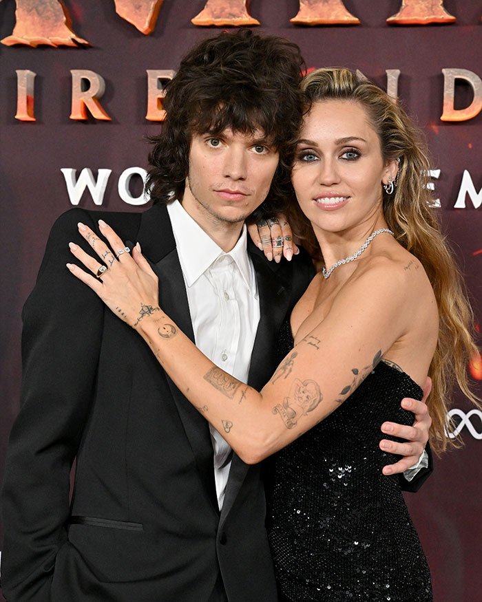 Miley Cyrus and Maxx Morando posing together at an event, highlighting engagement news and mixed reactions.
