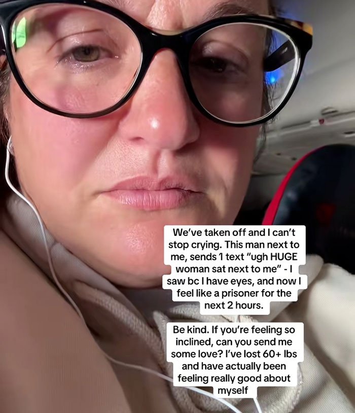 Close-up of woman wearing glasses on flight, visibly upset after catching seatmate’s body-shaming text message.