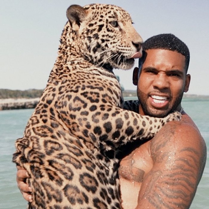 Man holding a large jaguar by the water, unrelated to Jurassic World star BD Wong apology over racist comment.