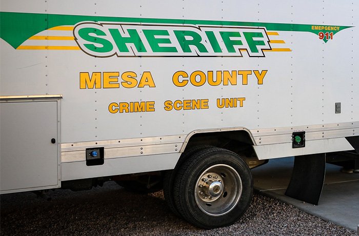 Mesa County sheriff crime scene unit vehicle parked, related to woman's chilling 911 call after attacking sleeping boyfriend.