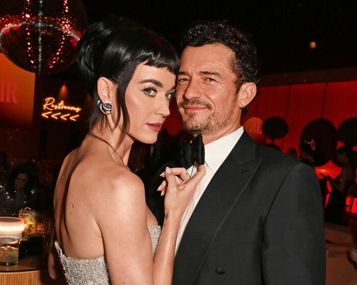 Katy Perry and Justin Trudeau dressed elegantly during a meeting with Japan's ex-prime minister in a formal setting.