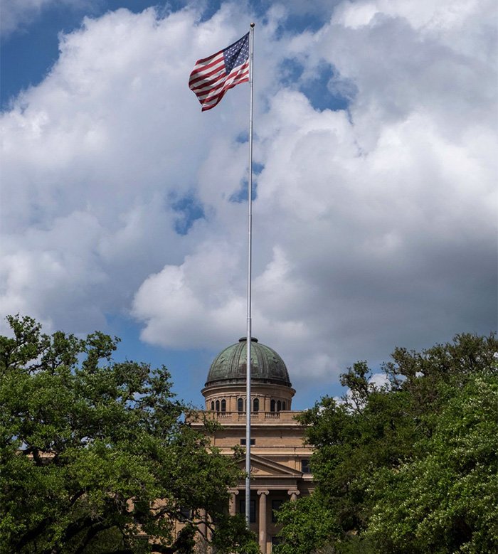 American flag flying above government building symbolizing mom of late cheerleader challenging cops' ruling after phone clue discovery