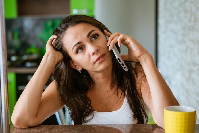 Upset woman talking on phone, reflecting on relationship issues after ex reacted strongly about bonding with their son.