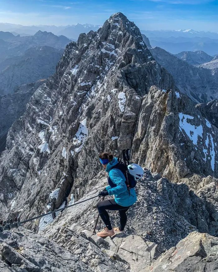 Woman climbing rugged snowy peak on Austria’s highest mountain, highlighting risks of fatal freezing and abandonment.