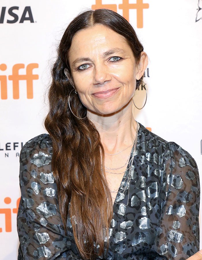 Woman with long brown hair and hoop earrings at a TIFF event, related to Jason Bateman raises eyebrows with sister Justine topic.