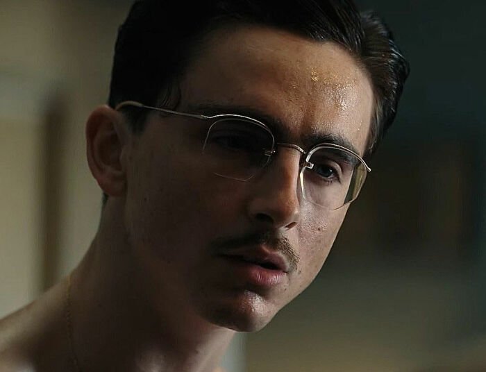 Close-up of Timothée Chalamet wearing glasses, showcasing his red carpet look with an unusual detail noticed by fans.