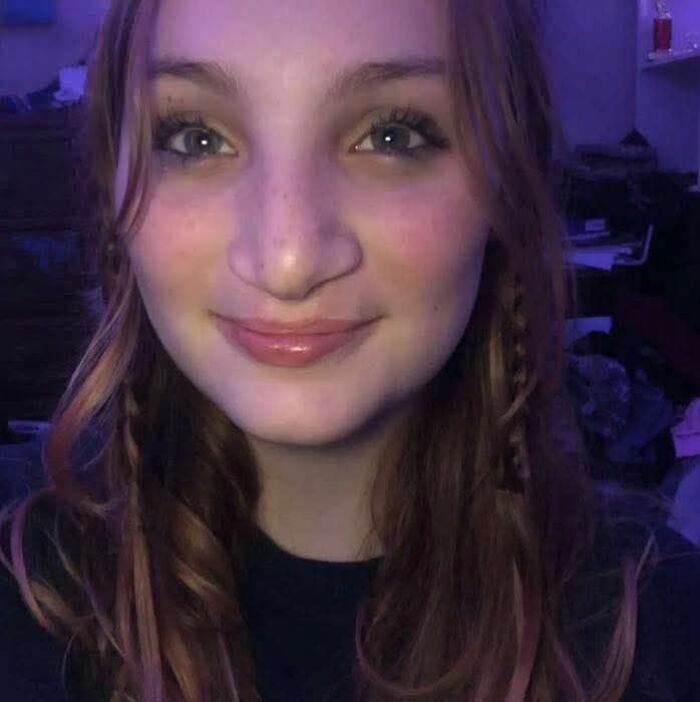 Young woman with long hair smiling softly, highlighting the disturbing tactic accused teens used to lure daughter into woods before attack.