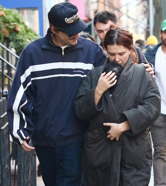 Millie Bobby Brown walking with partner outdoors, embracing her newborn daughter amid viral theory after new photos surfaced.