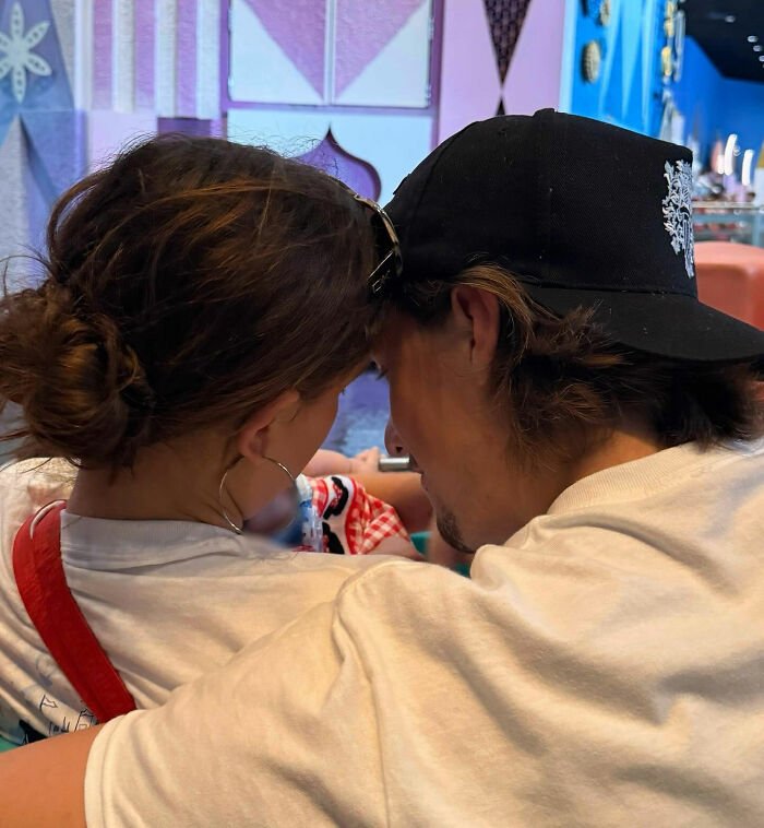 Couple closely looking at a newborn daughter, capturing a viral theory about Millie Bobby Brown's newborn daughter after new pics.