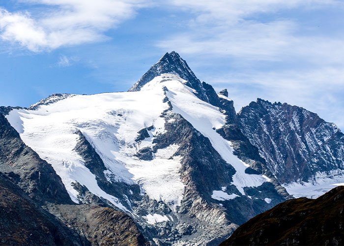 Snow-covered Austrian mountain peak under a blue sky, related to boyfriend who abandoned woman on Austrian mountain story.