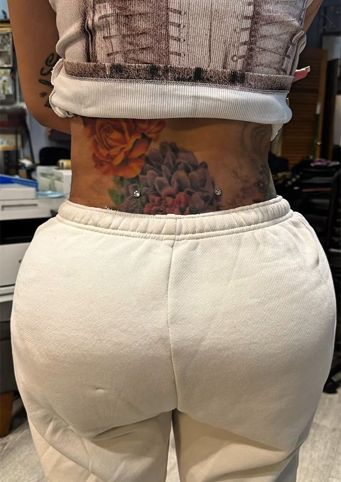 Close-up of new neck and back piercings on tattooed skin, highlighting fresh body modifications and jewelry details.