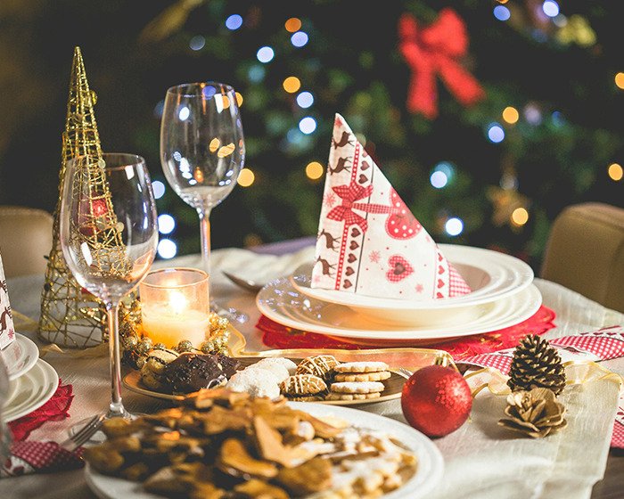 Festive holiday table setting with Christmas decorations and desserts in a scene related to decolonized Christmas.