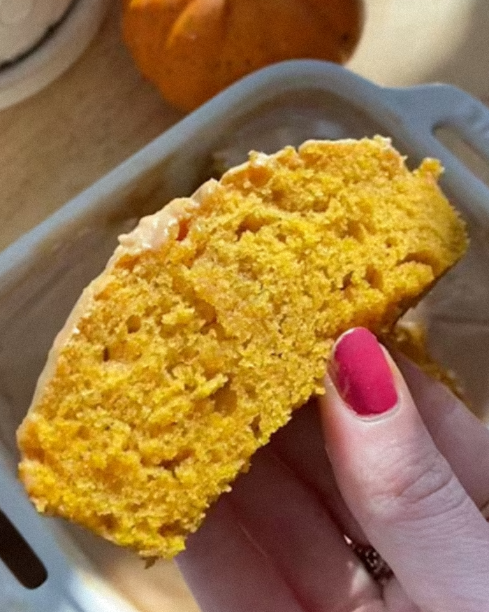 Hand holding a slice of orange pumpkin bread, highlighting the decolonized Christmas recipe by a woke social media user.