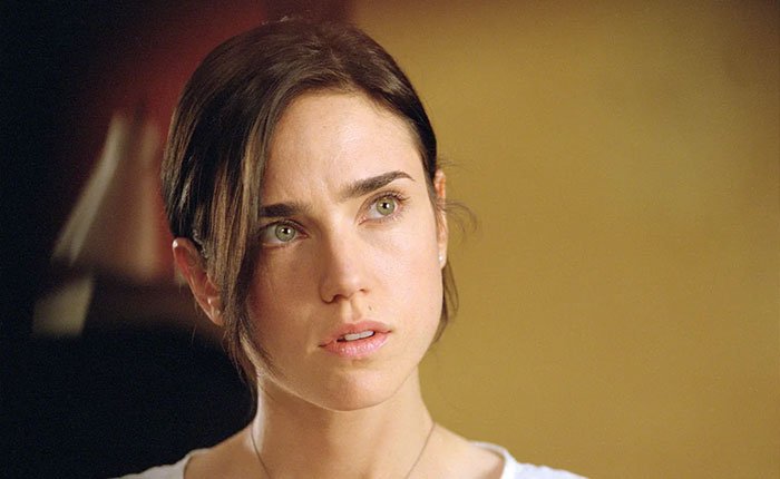 Jennifer Connelly in a close-up, reflecting on her iconic movie scene and career regrets in a softly lit setting.
