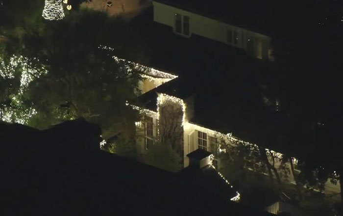 A large house lit with white holiday lights at night, related to son eyed as person of interest in LA case.