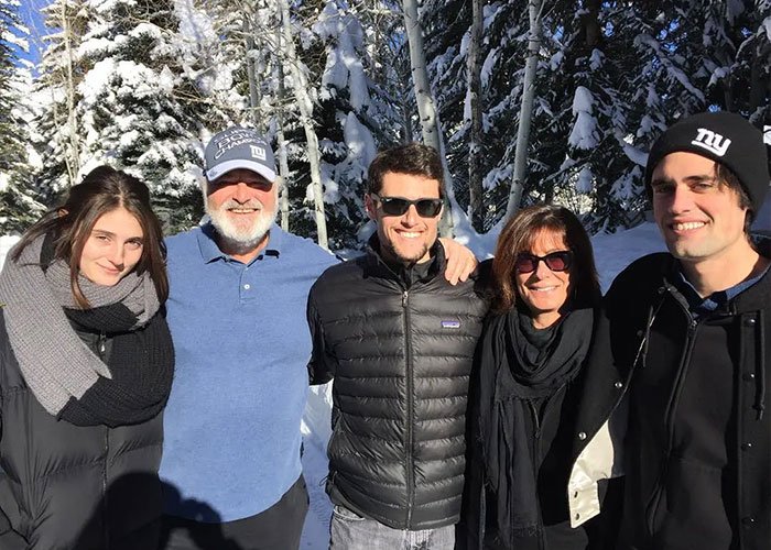 Group of five people outdoors in winter clothing with snowy trees in the background related to Trump controversy over Rob Reiner and wife.