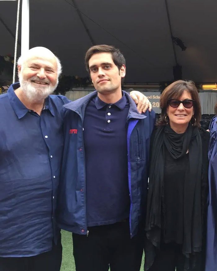 Rob Reiner and son Nick standing together outdoors, casually dressed, at a social gathering.