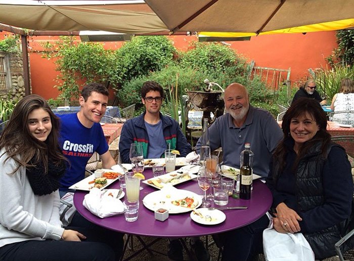 Group of people sitting outdoors at a round table enjoying a meal, relating to Michelle Obama breaking her silence.