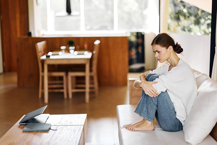 Woman sitting on couch looking frustrated, thinking about entitlement to day off on Christmas because of kids.