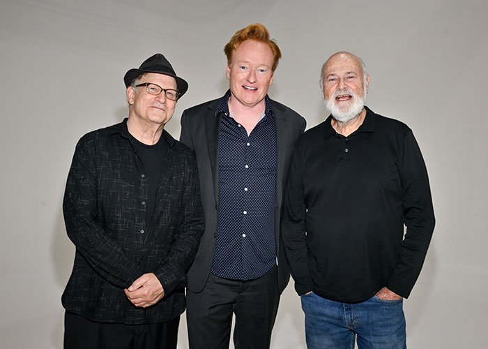 Rob Reiner standing with two men at a party, capturing a moment linked to reported confession about son.