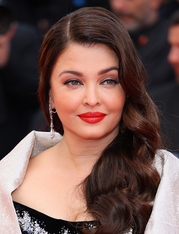 Close-up of a celebrity with red lipstick and wavy hair, showcasing the beauty aligned with the golden ratio concept.