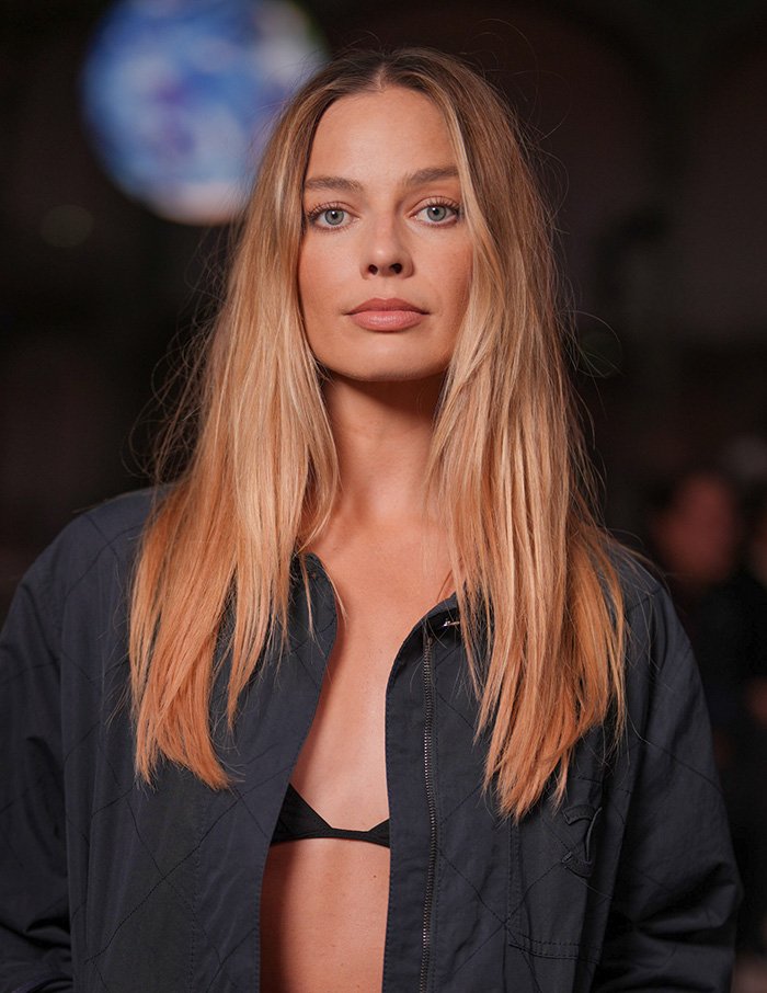 Blonde woman with long hair wearing a dark jacket highlighting beauty based on the golden ratio concept of celebrities.