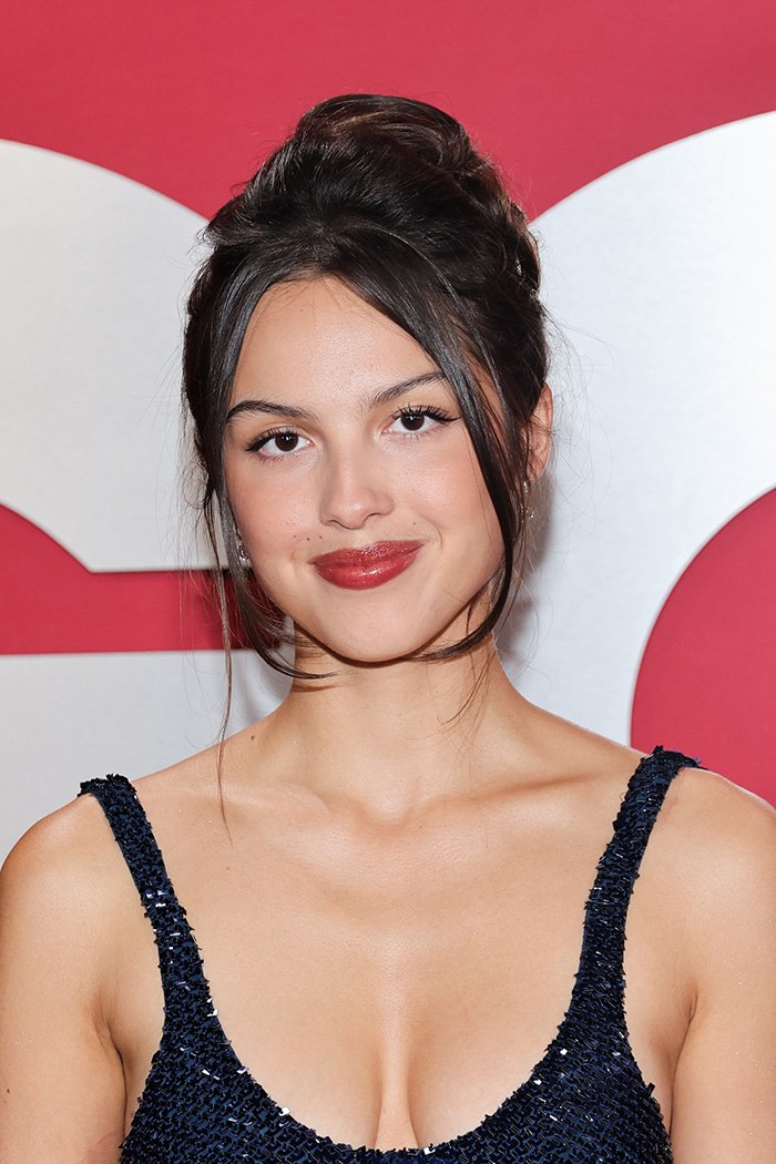 Young woman with elegant updo and red lipstick wearing a dark blue dress, representing beautiful celebrities and golden ratio standards.