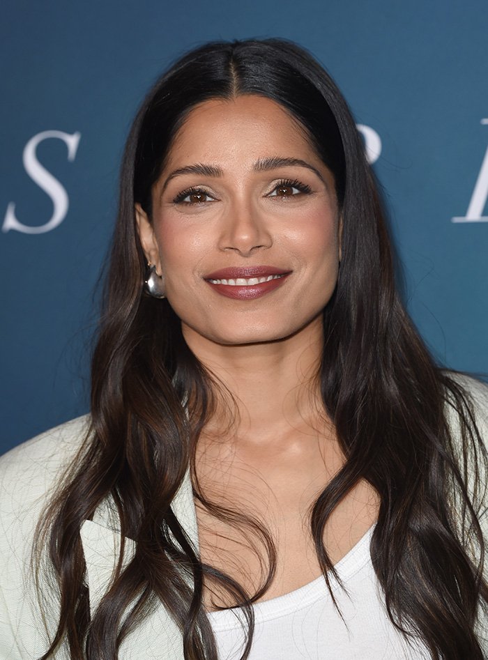 Close-up of a beautiful celebrity with long dark hair and natural makeup, exemplifying the golden ratio beauty standards.