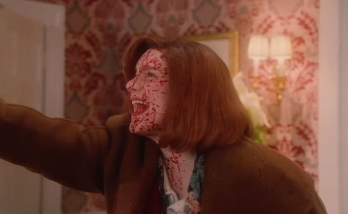 Woman with blood-splattered face in a horror scene from SNL’s Home Alone parody starring Ariana Grande.