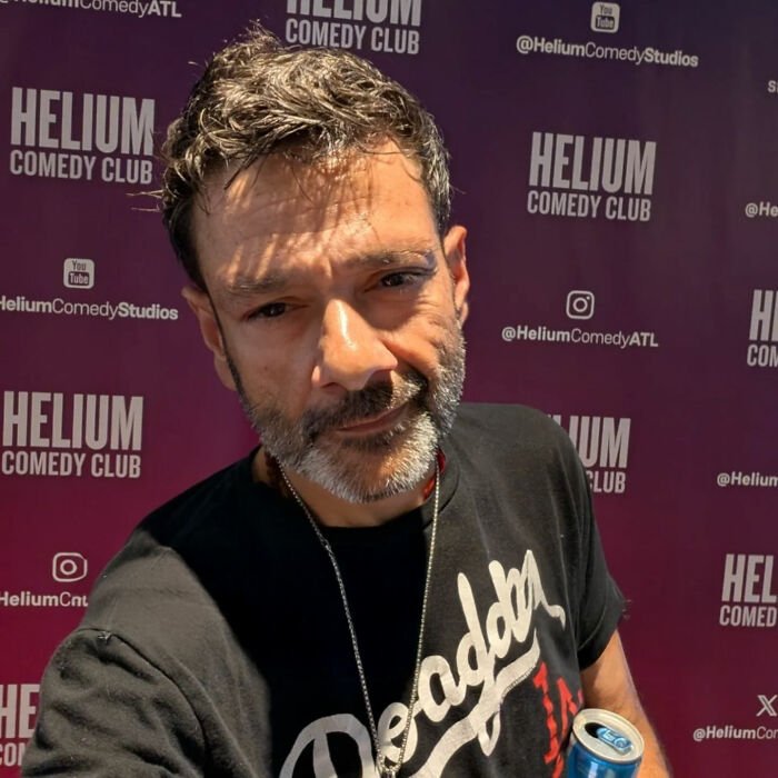 Man with salt-and-pepper hair and beard at Helium Comedy Club, discussing Tylor Chase homelessness and urgent request.