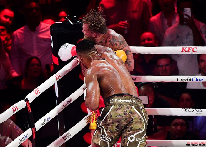 Boxer landing a punch during a match, highlighting Jake Paul’s broken jaw as the latest internet punchline in boxing.