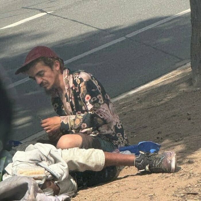 Man believed to be dad of Nickelodeon star Tylor Chase sitting on the sidewalk, showing signs of homelessness and health struggles.