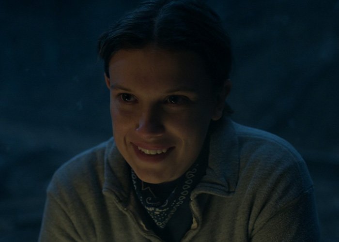 Millie Bobby Brown smiling in a dark scene from Stranger Things, capturing fans’ attention with this viral shot.