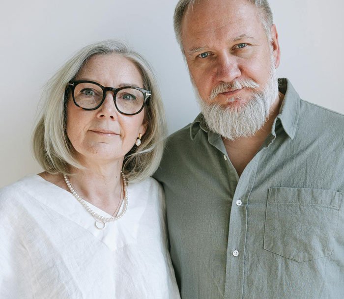 Middle-aged couple standing close together, conveying emotions related to family and disownment themes.