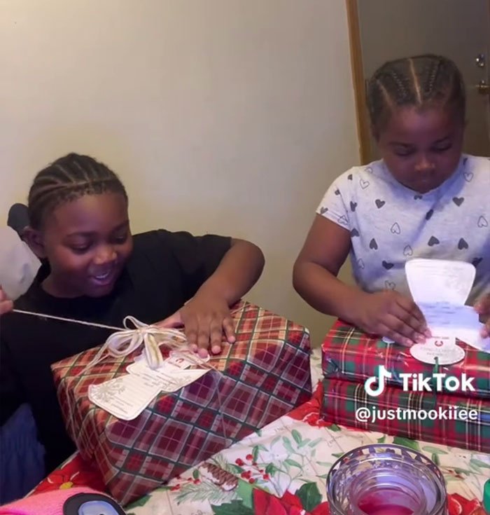 Two children opening Angel Tree gifts at a table, capturing son’s reaction in a viral mom’s video on TikTok.