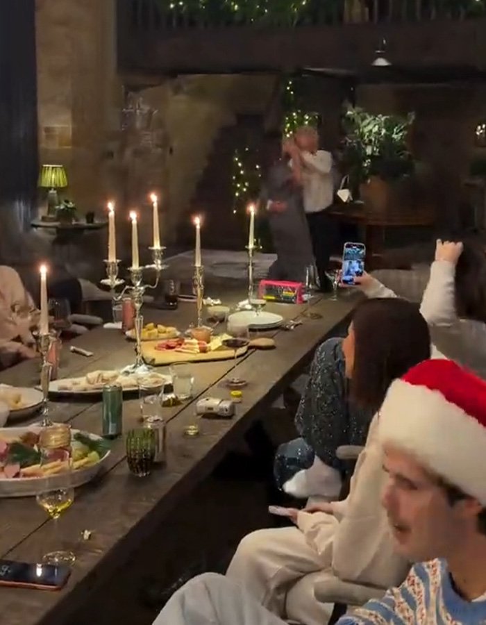 Holiday gathering with festive candles, people celebrating indoors, fans discuss Brooklyn’s wife Nicola Peltz and Victoria posts.