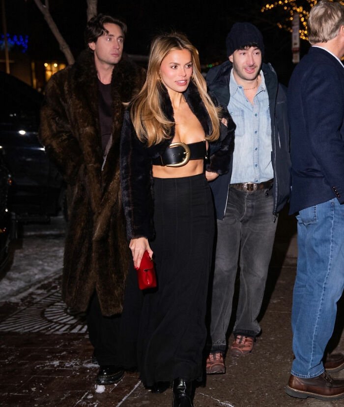 Brooks Nader wearing a $1,260 Santa belt as a shirt while walking in Aspen at night with friends.