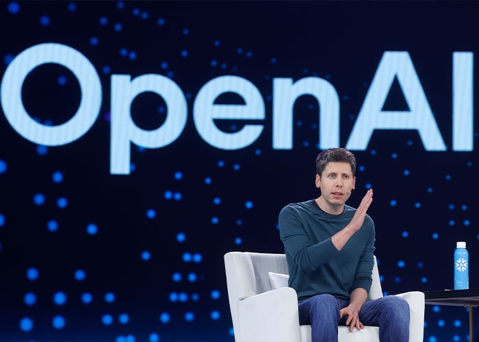 Person speaking on stage with OpenAI logo in background, highlighting ChatGPT controversy after teenager's tragic outcome.