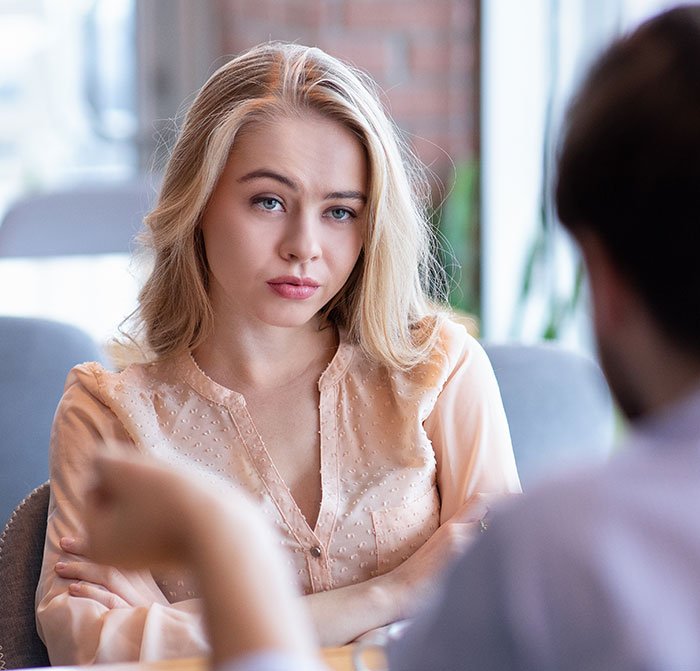 Young woman with arms crossed, showing a rude attitude, representing millennial women in the post-Karen era conversation.