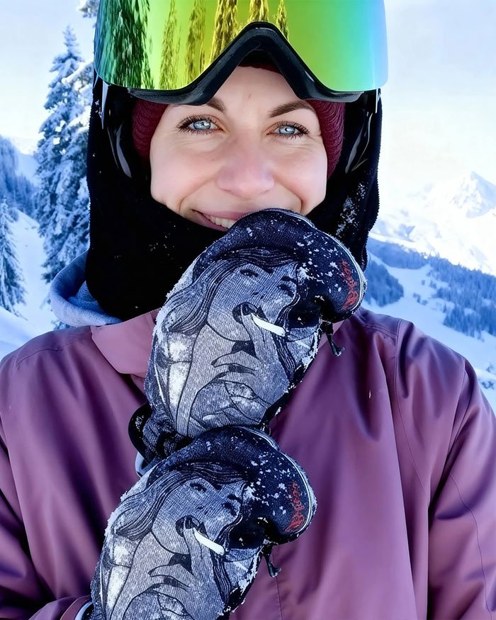Smiling woman wearing ski goggles and gloves on snowy Austrian mountain, linked to boyfriend who abandoned her.