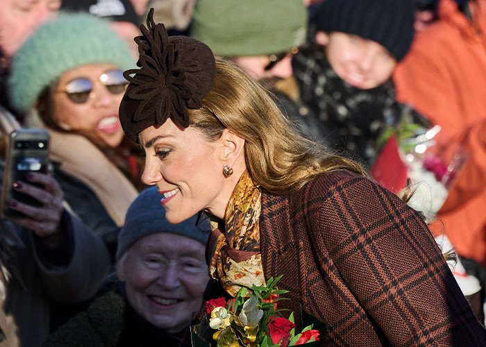 Kate Middleton with a floral headpiece, showing a visible facial scar during a public appearance in winter attire.