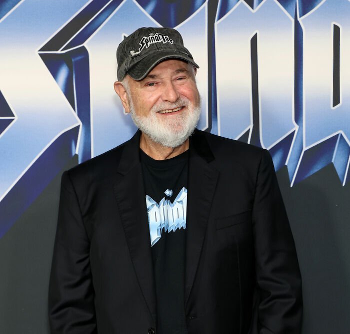Rob Reiner smiling at an event, wearing a black jacket and hat, highlighting MAGA hypocrisy discussions.