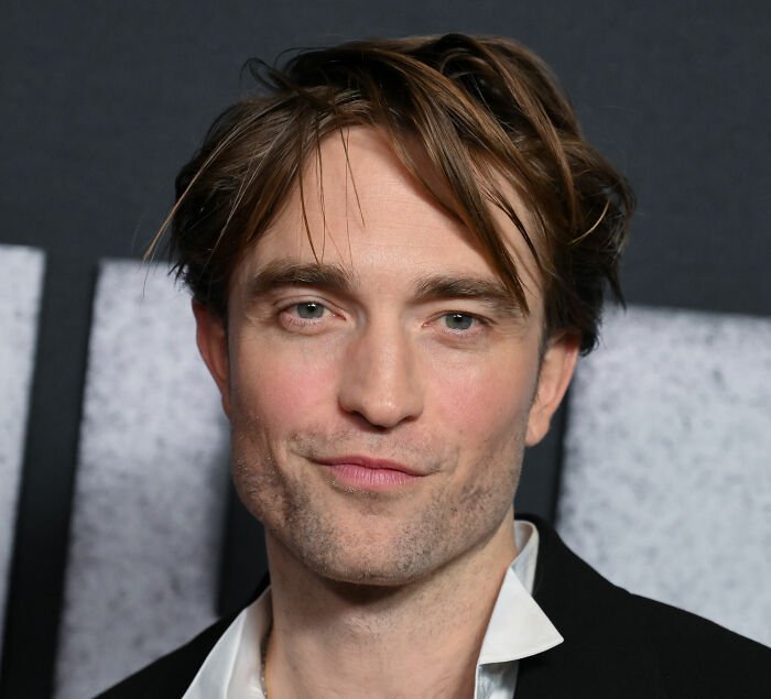 Robert Pattinson close-up portrait at event, highlighting viral engagement ad and recent public confession.