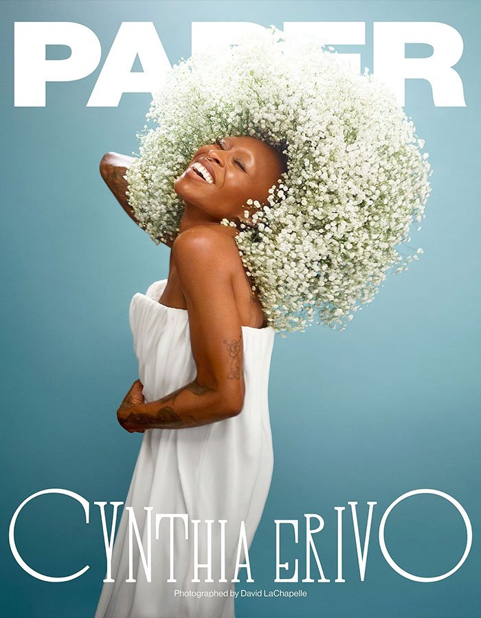 Cynthia Erivo on magazine cover wearing white dress and large flower headpiece celebrating Wicked For Good success