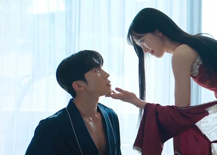 A Korean couple sharing an intimate moment in a softly lit room, evoking K-drama-style romantic encounters.