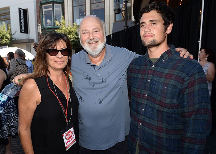 Rob Reiner's son with two people at an outdoor event, capturing a moment that involves celebrities and a party setting.